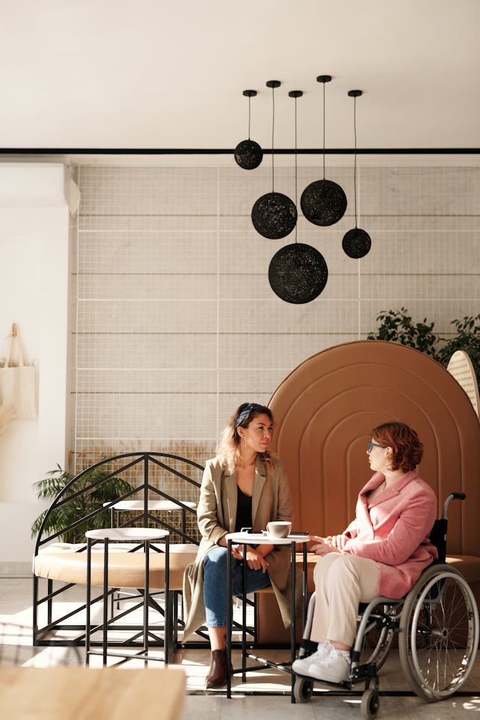 Two women having a thoughtful discussion in a modern café setting, highlighting inclusivity.
