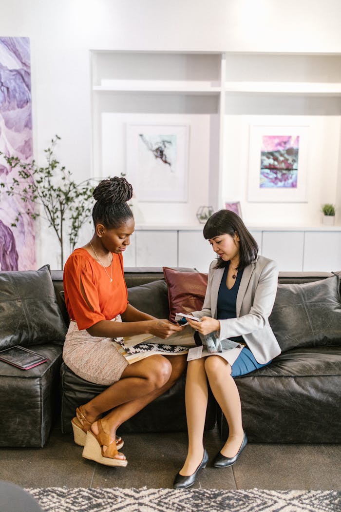 programs-01 Two women discussing business in a stylish office lounge.
